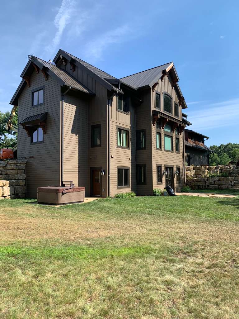 Large dark brown luxury home after painting